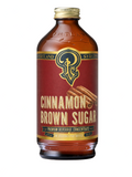 A bottle of Portland Cinnamon Brown Sugar Premium Beverage Concentrate, featuring an amber glass bottle with a gold cap and a deep red label with gold and green accents.