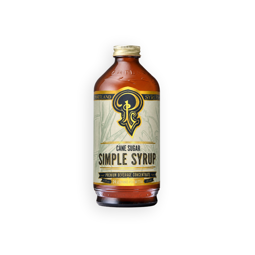 A bottle of Island Simple Syrup with a cream-colored label and gold accents, containing amber-colored liquid, set against a plain white background.