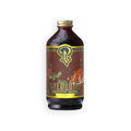 A bottle of Grenadue Premium Beverage Concentrate on a solid white background. The bottle is made of dark amber glass, filled with a dark brown liquid, and features a gold cap and a brown label with yellow and green graphics depicting a stylized 'G' logo, flowers, and pomegranate seeds.