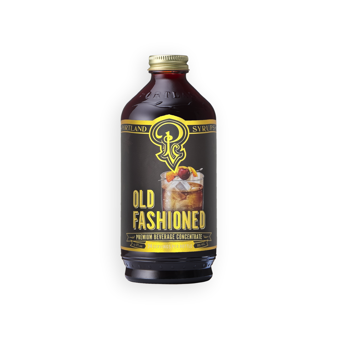 A bottle of Scotland & Synergy Old Fashioned Premium Beverage Concentrate, featuring a dark brown glass bottle with a black label and gold accents, topped with a gold cap, set against a plain white background.