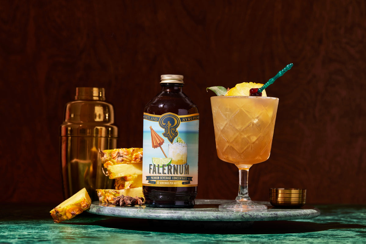 Flernum bottle with a cocktail garnished with pineapple on a dark background