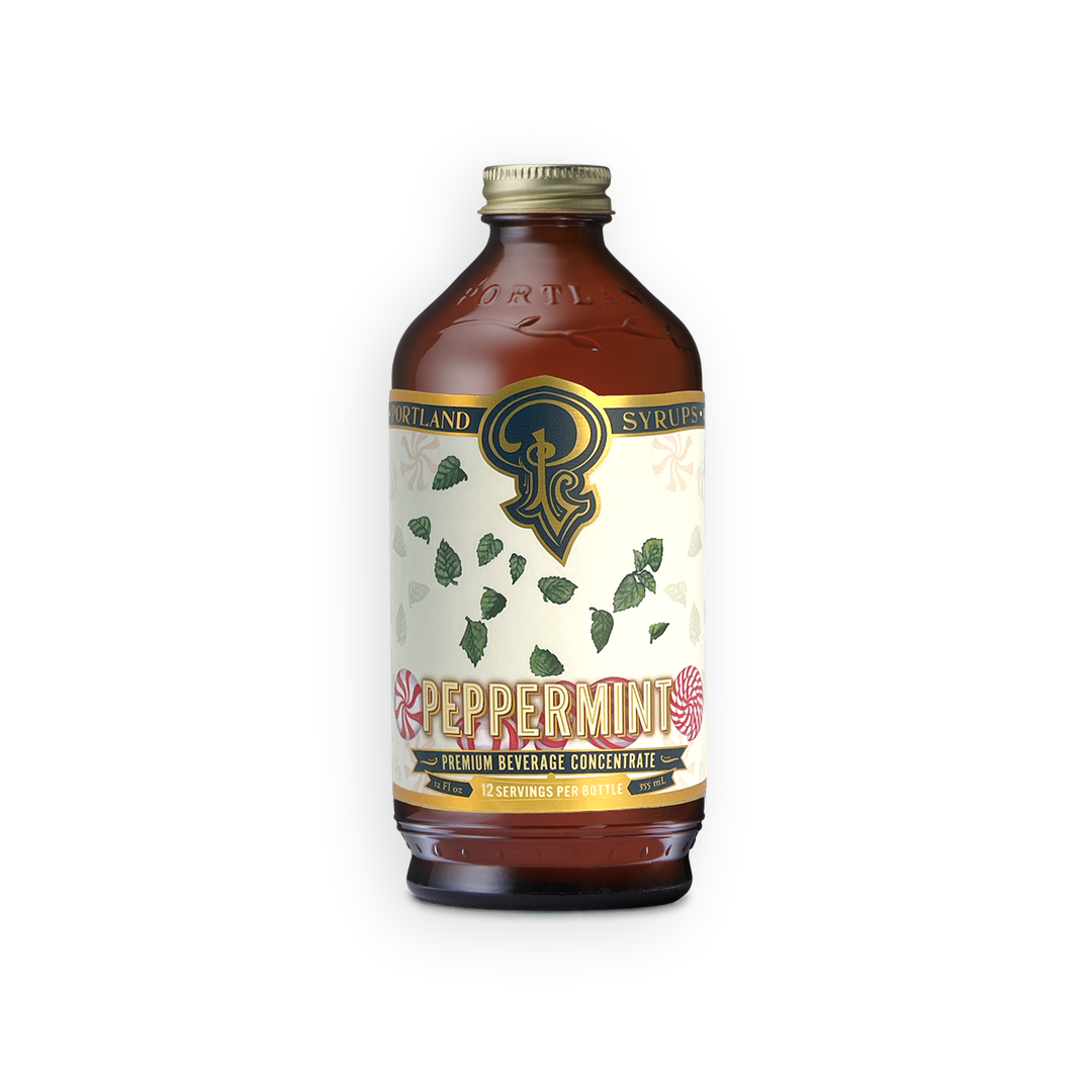 A bottle of Scotland Syrup's Peppermint Premium Reverse Concentrate, featuring an amber glass bottle with a cream-colored label decorated with green peppermint leaves and a gold cap.
