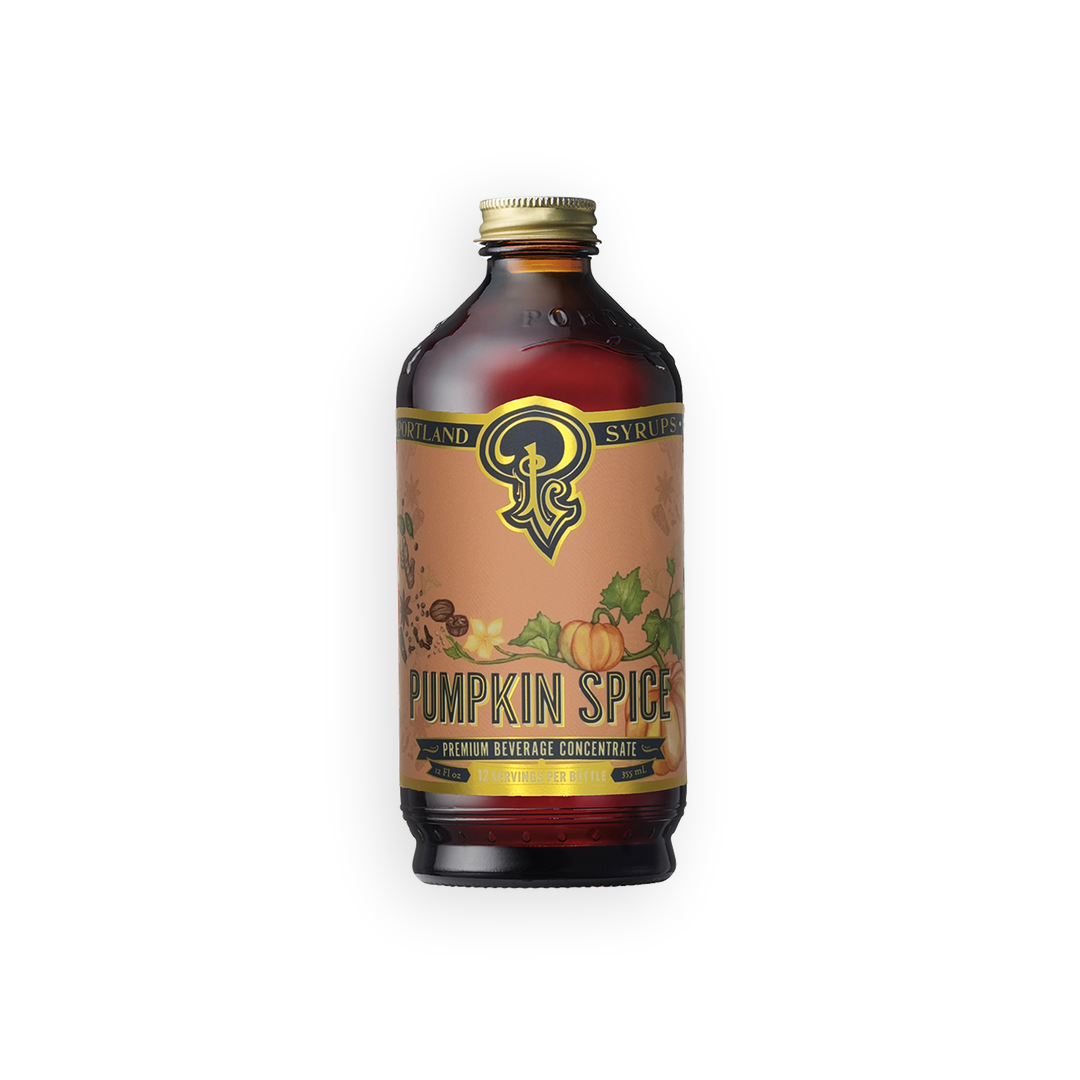 A bottle of Syrupland Pumpkin Spice Honey Syrup Concentrate with a gold cap and a tan label featuring autumn illustrations, set against a plain white background.