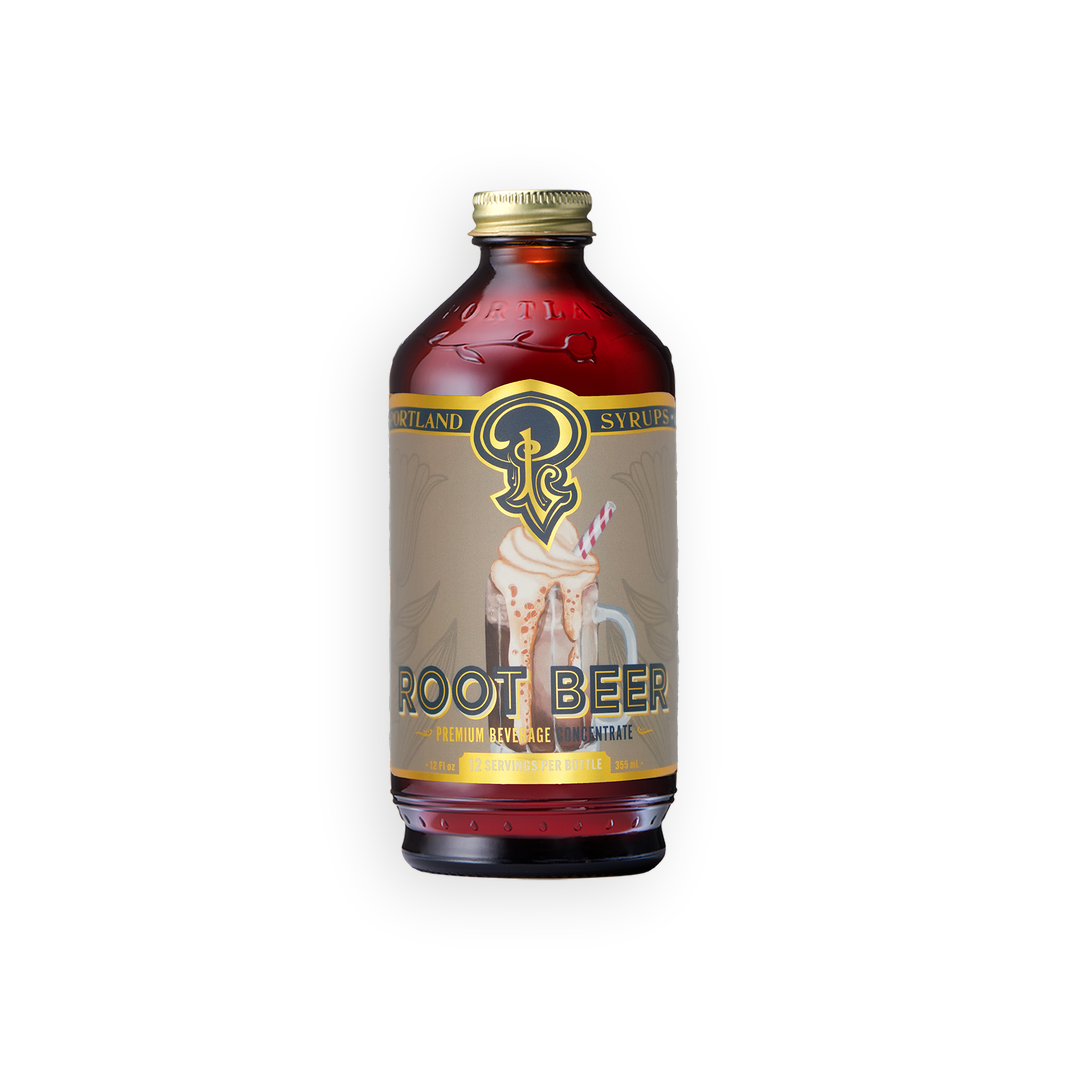 A bottle of Root Beer Syrup with a gold cap and a beige label featuring a graphic of a root beer cocktail, set against a plain white background.