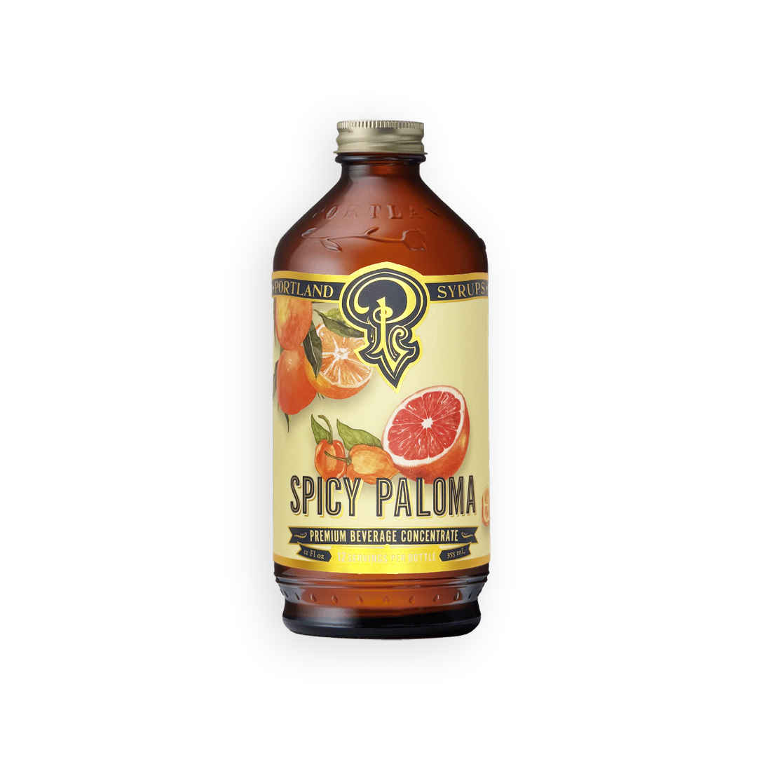A bottle of Syrupland Spicy Paloma premium beverage concentrate, featuring an amber glass bottle with a cream-colored label and citrus illustrations, set against a plain white background.